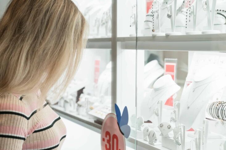 Rapariga a ver uma montra com ouro