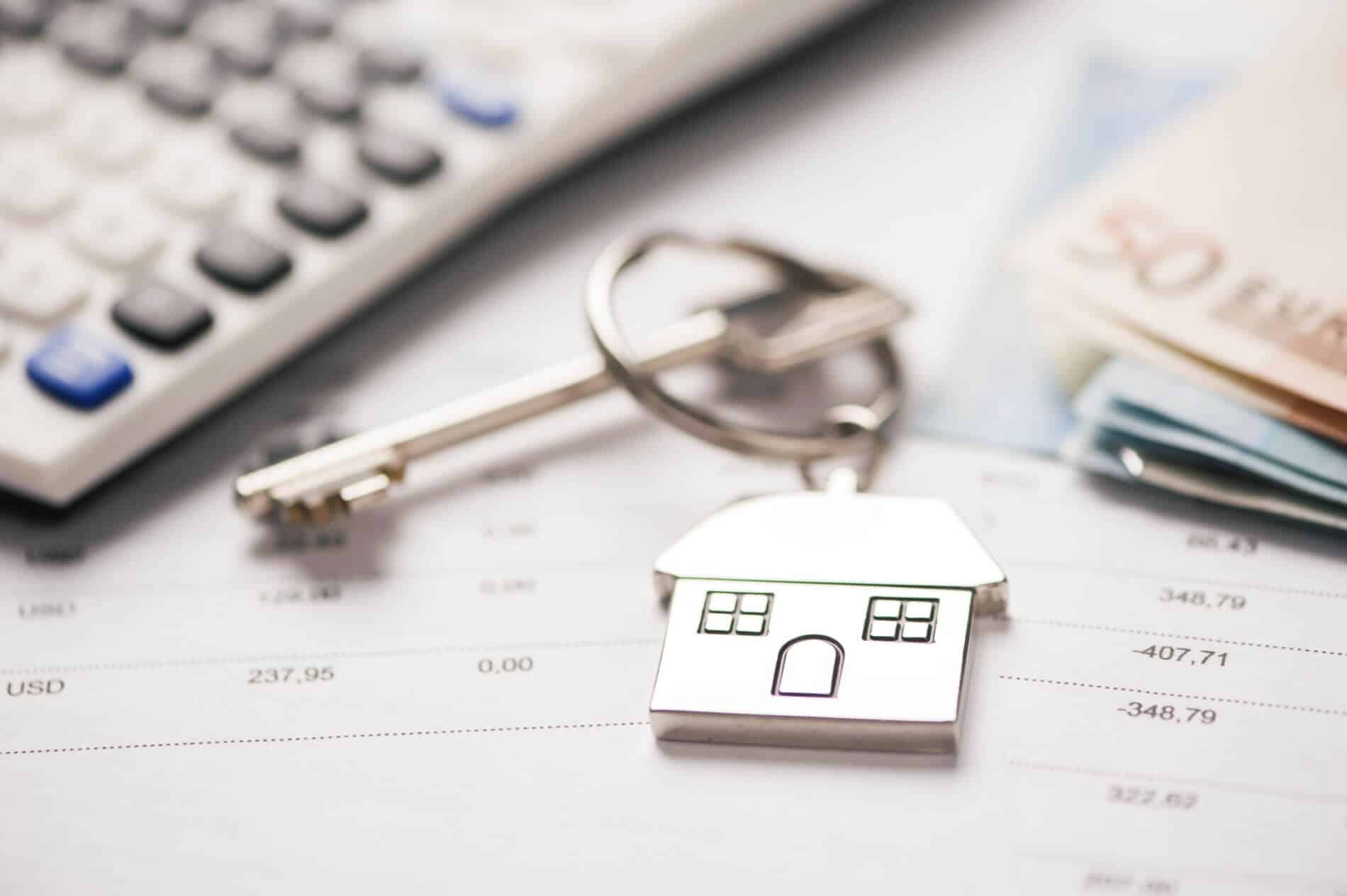 porta-chaves e calculadora que representam os custos durante as várias fases de um crédito habitação