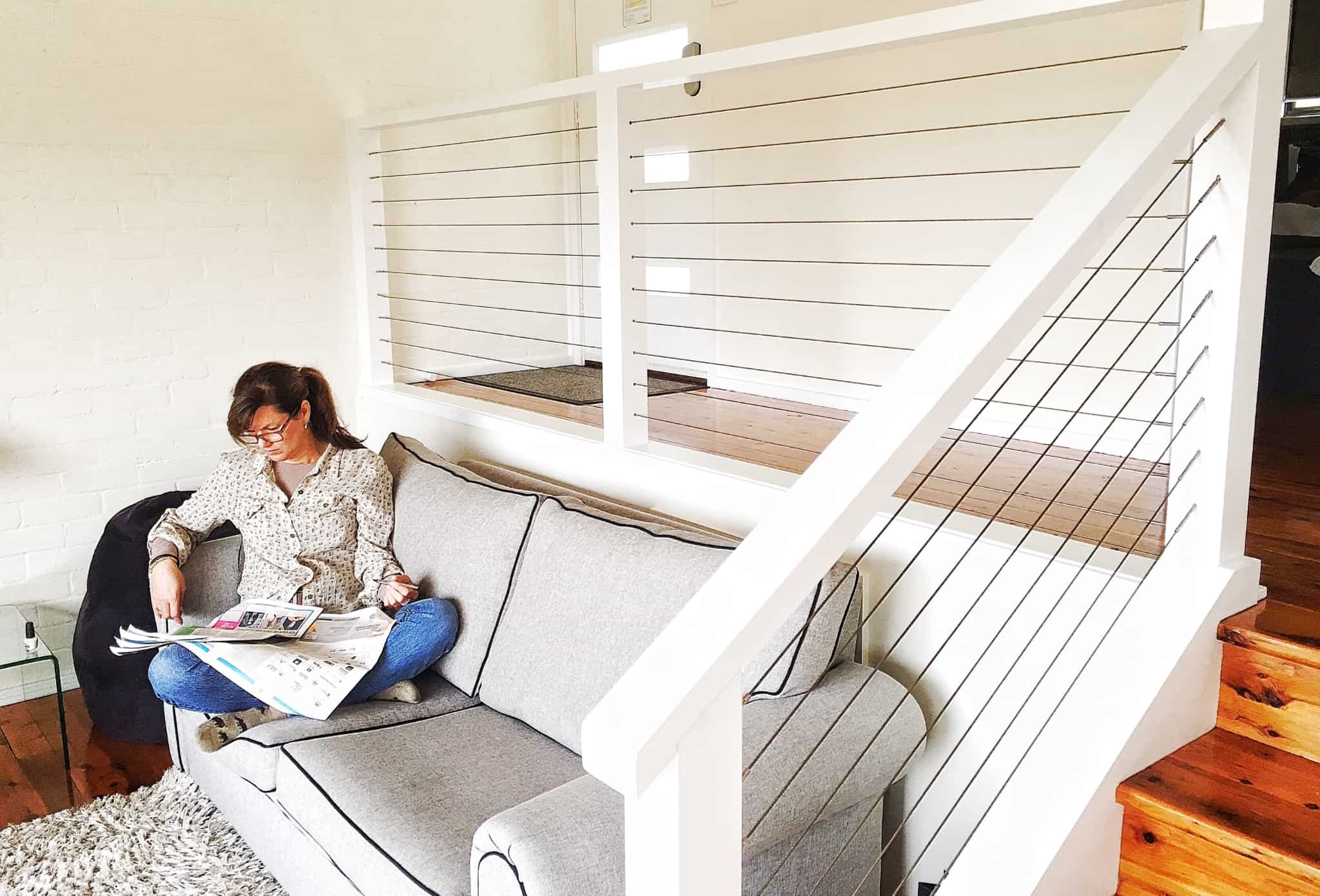 mulher sentada no sofá a ler o jornal