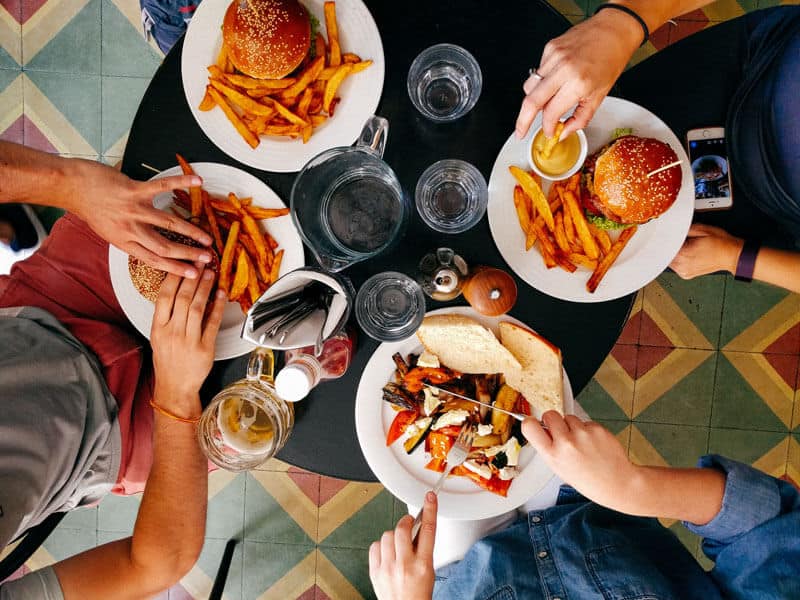 mesa com 3 pratos de hamburgueres