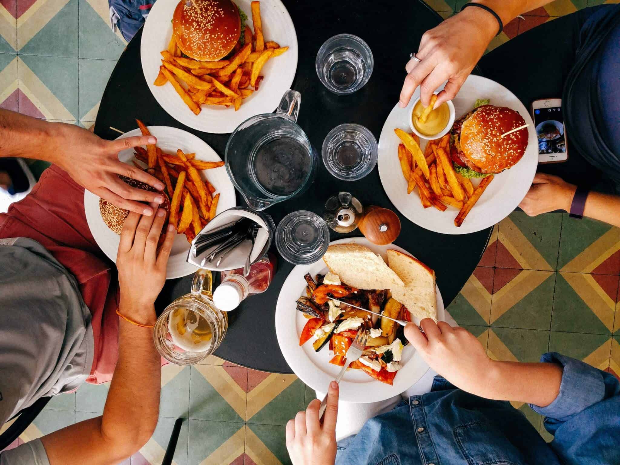 amigos reunidos à mesa com comida e bebida