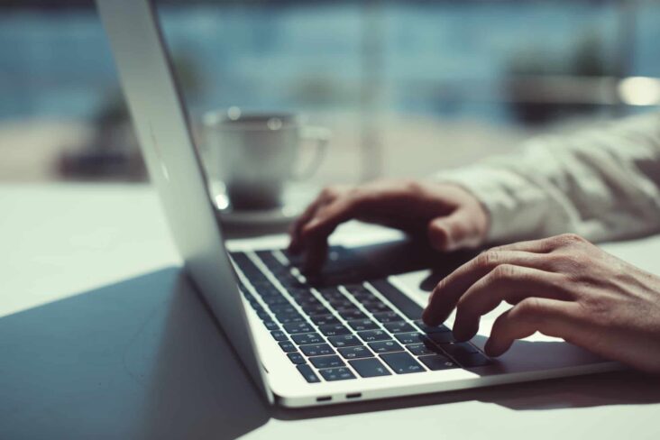 pessoa a trabalhar no laptop de teclado preto