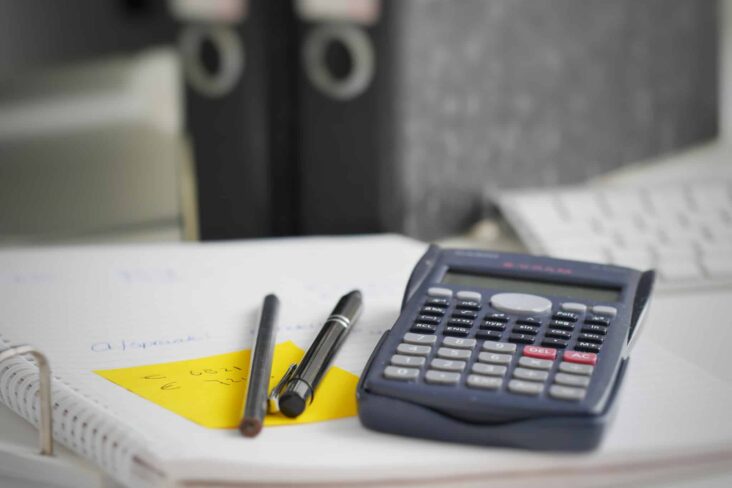 calculadora em cima de papeis de um dossier