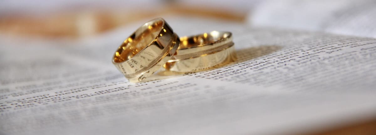 alianças de outro sob um livro aberto simbolizam a união, o casamento