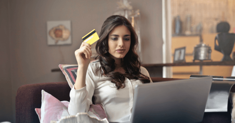 rapariga a segurar cartão amarelo na mão com o computador ao colo