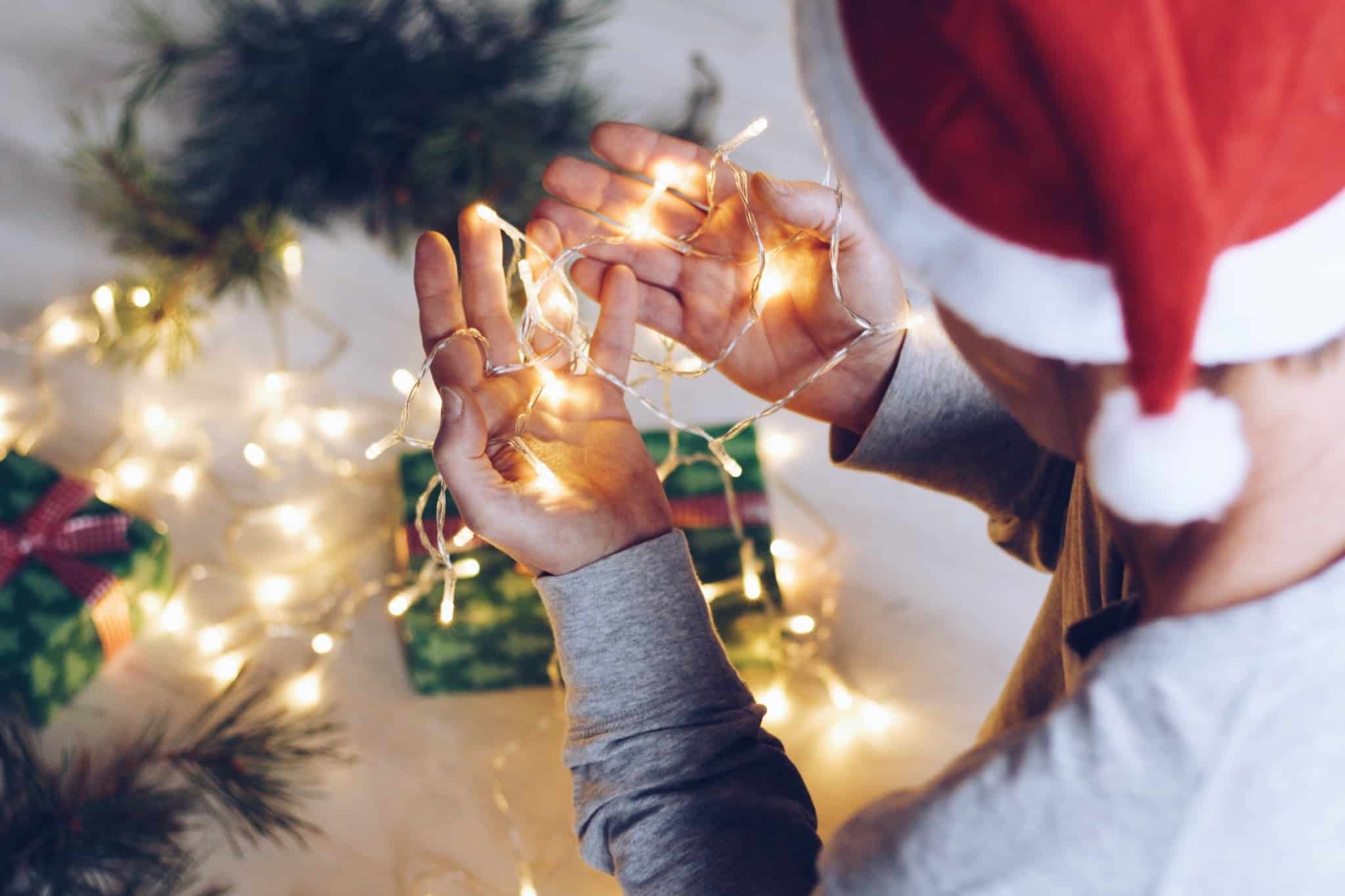 pessoa a segurar luzes de natal