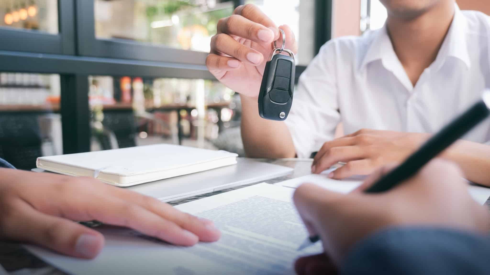 Vender o carro sozinho: como conseguir um negócio seguro? pessoa a comprar carro a segurar a chave do carro