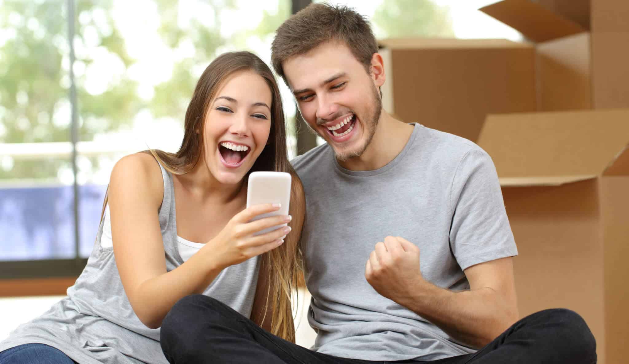 casal satisfeito a olhar para o telemóvel
