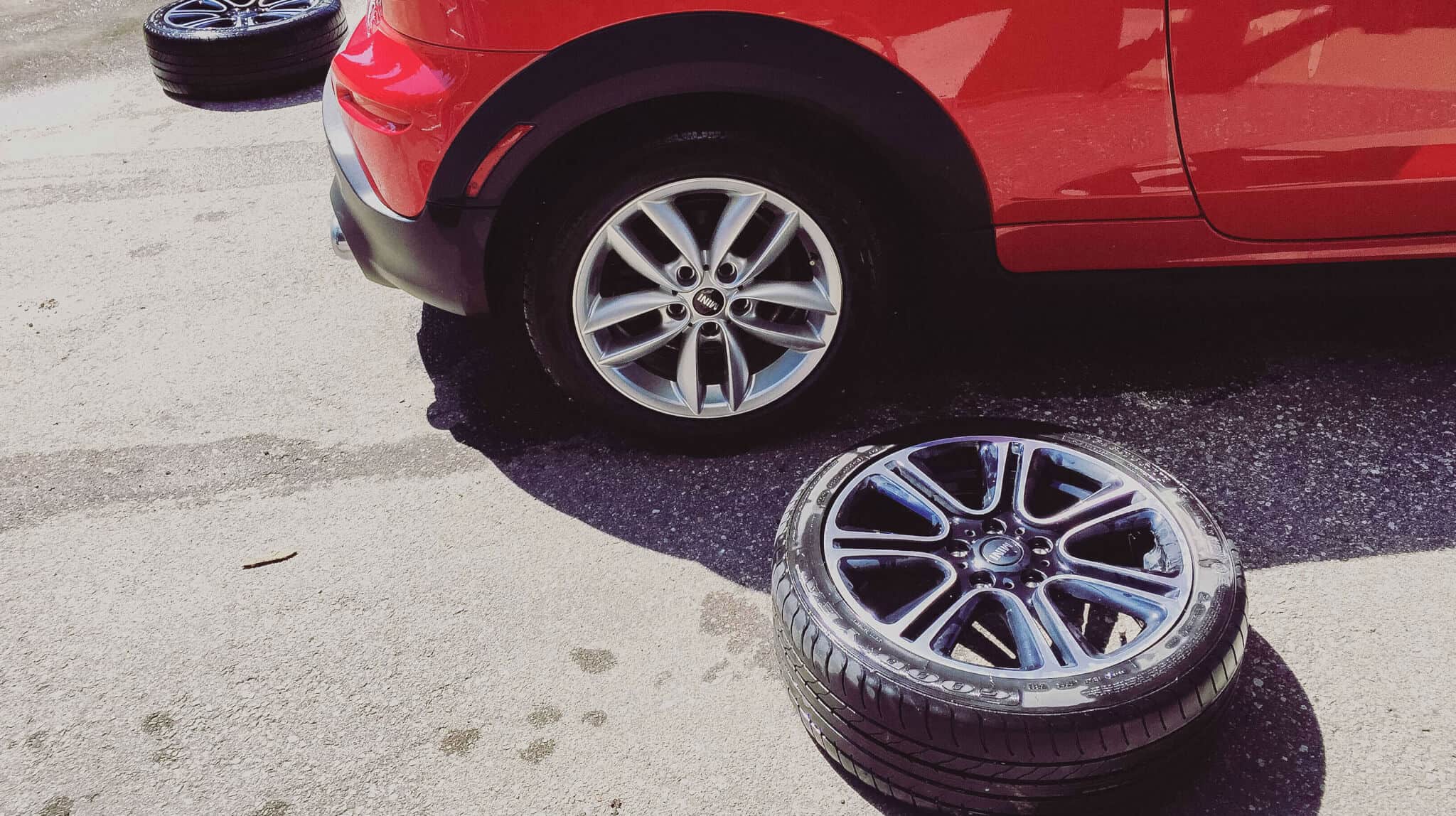 reparação do carro, com a troca de pneu num carro vermelho
