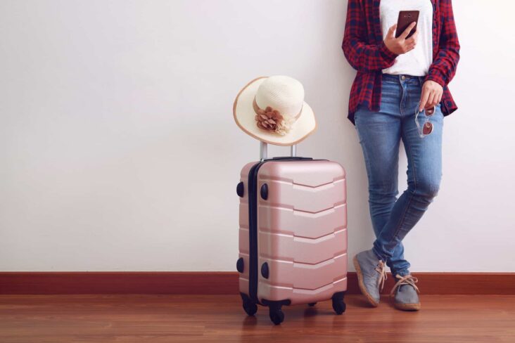 rapariga pronta para viajar com trolley de viagem