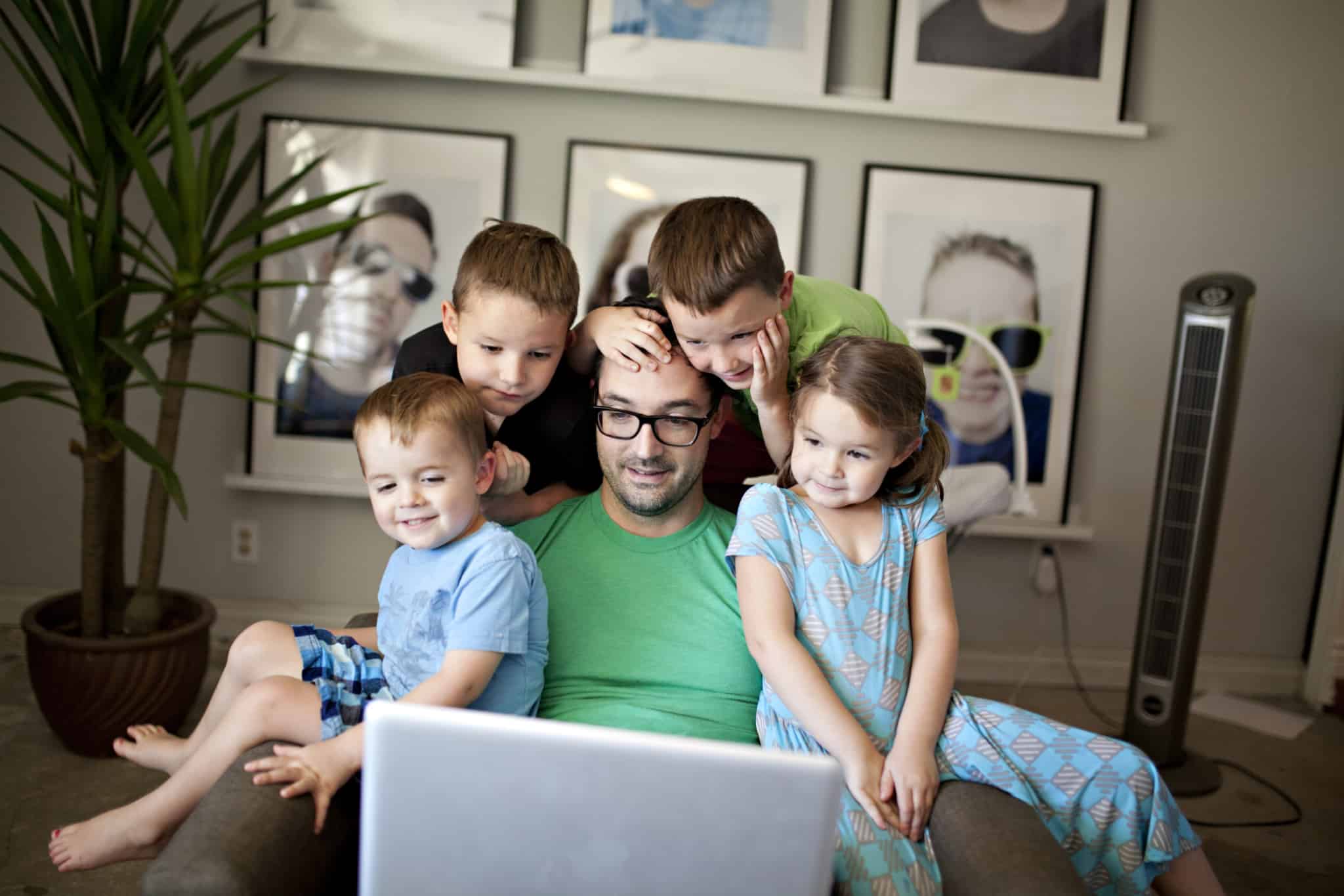 Pai com os filhos sentados no sofá Família