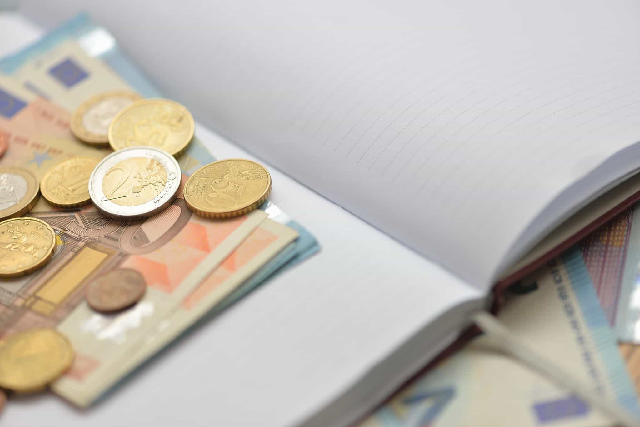 caderno aberto com moedas lá dentro