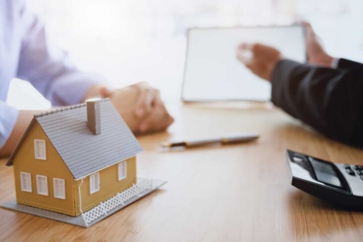 duas pessoas reunidas com uma calculadora em cima da mesa - mais-valias - herança