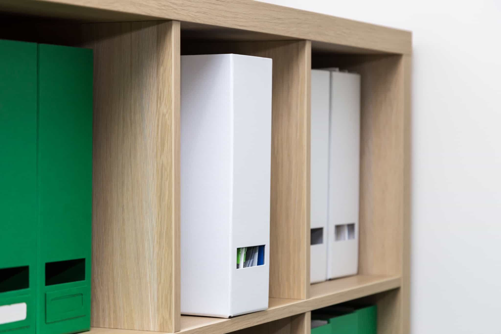 estante de madeira com dossiers brancos