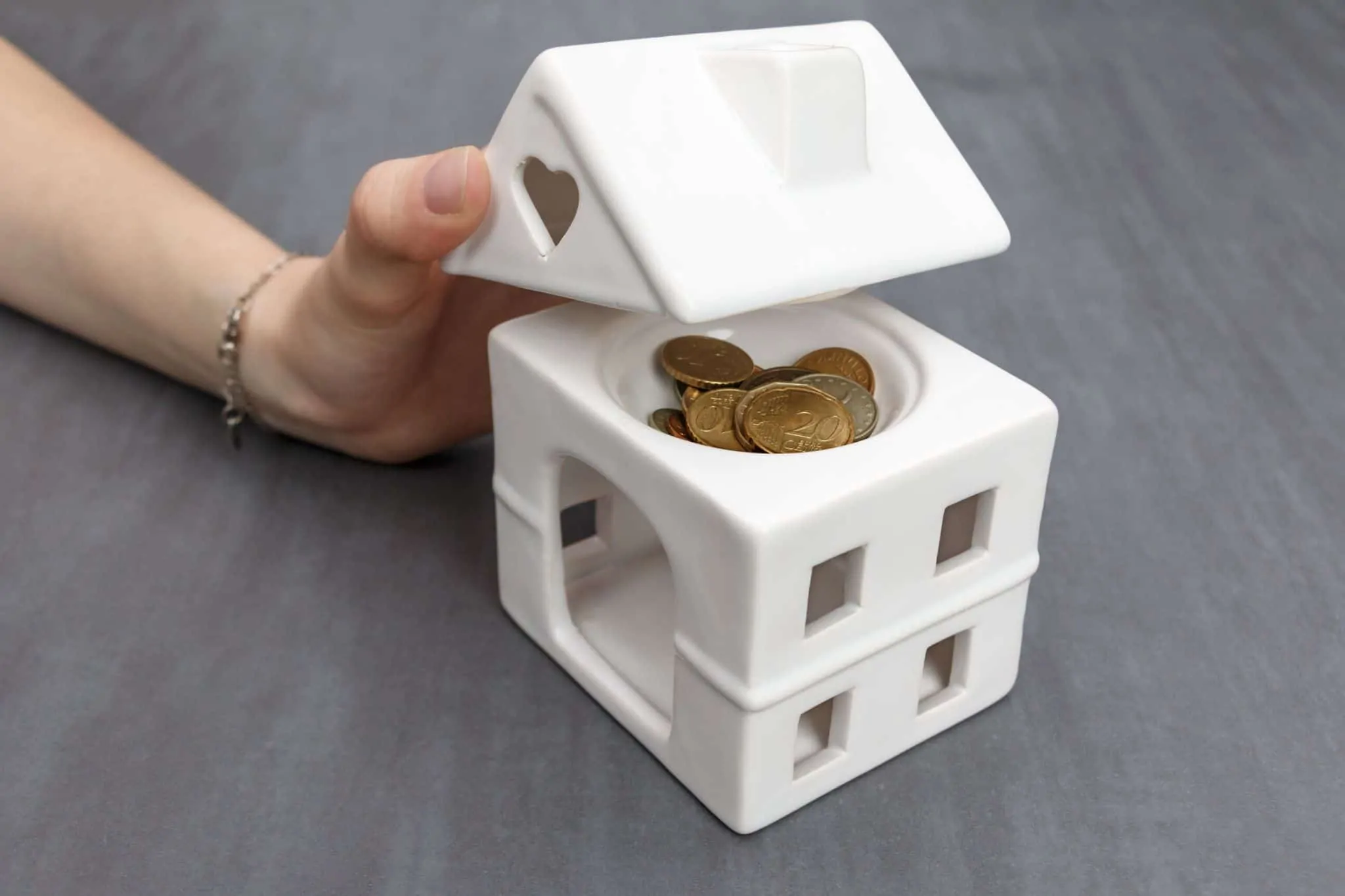 Quem tem direito à isenção de IMI? casa em miniatura com moedas lá dentro