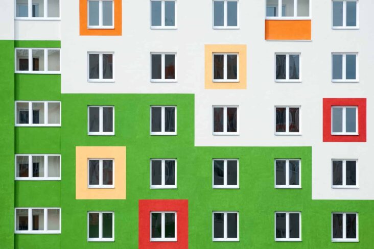 prédio metade verde e metade branco com janelas