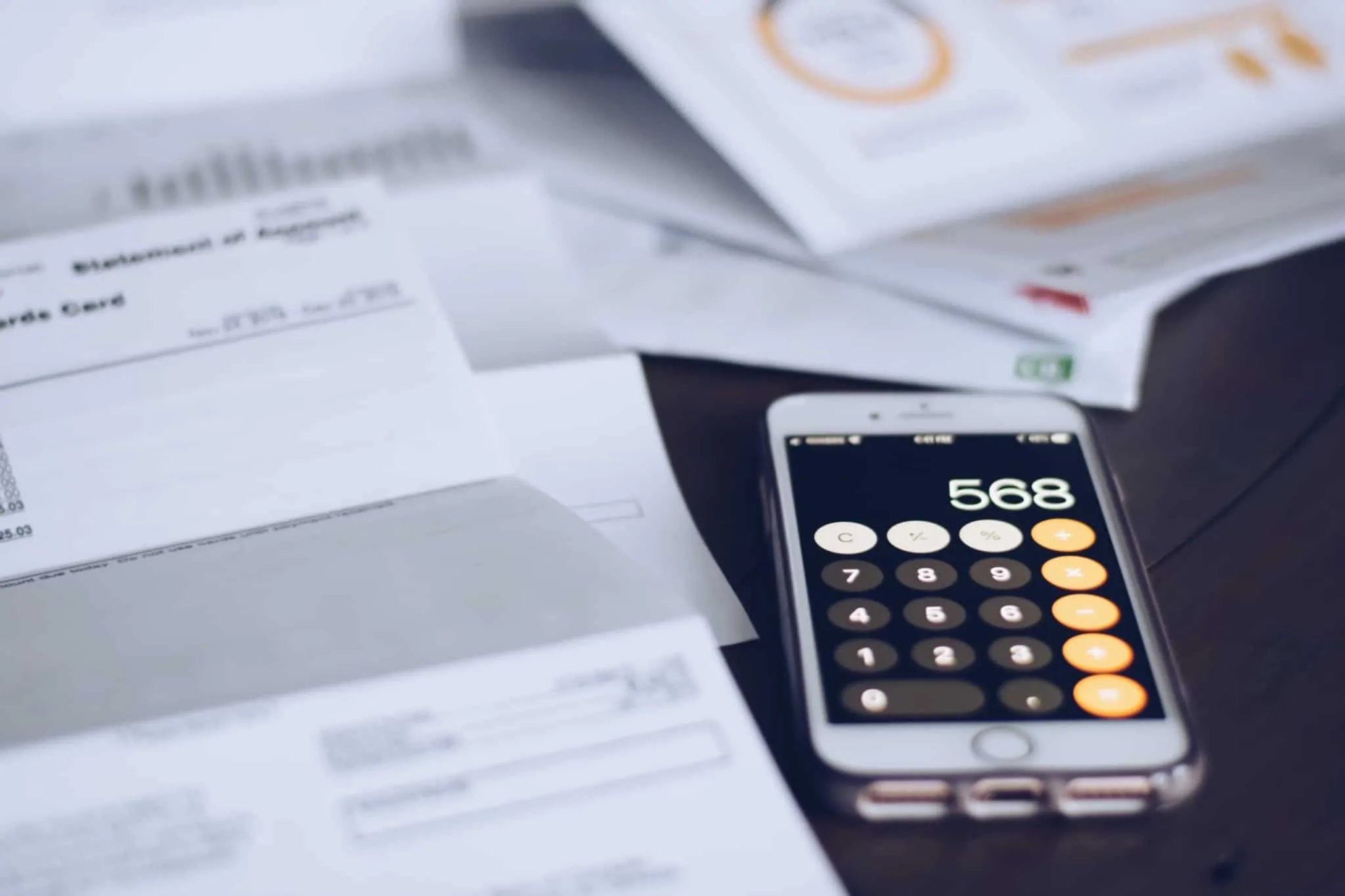 várias faturas e um telemóvel com calculadora