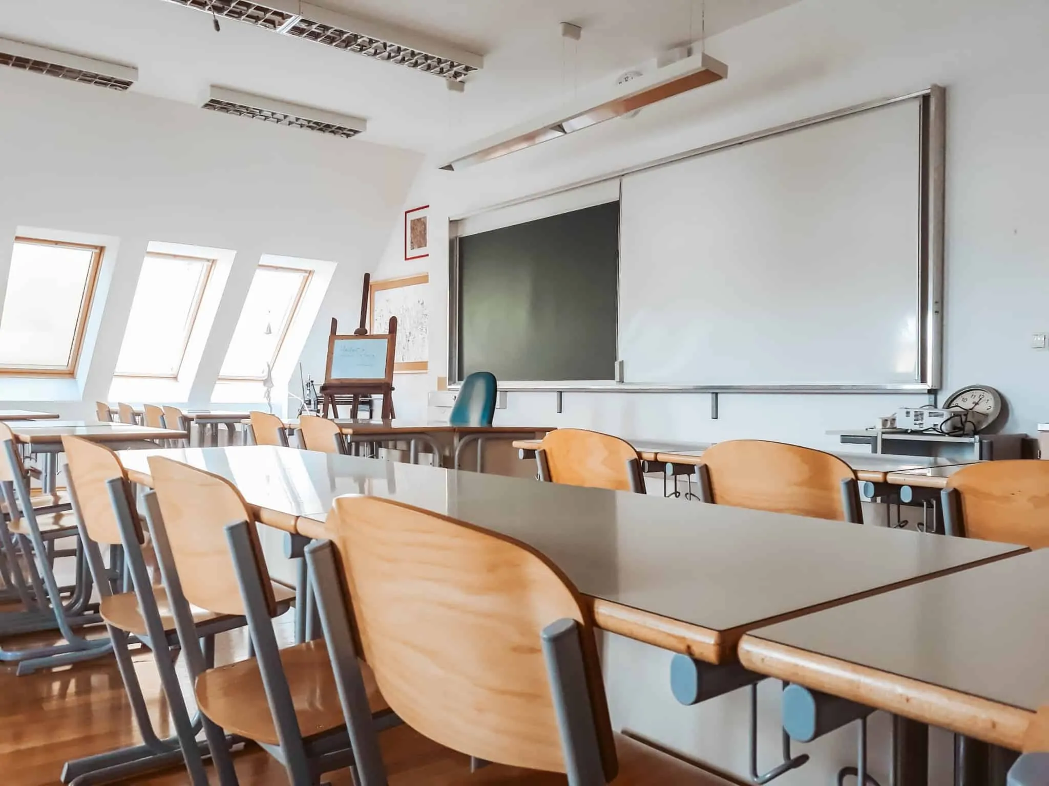 O que são prioridades de seriação no acesso ao ensino? sala de aula com cadeiras de madeira vazias