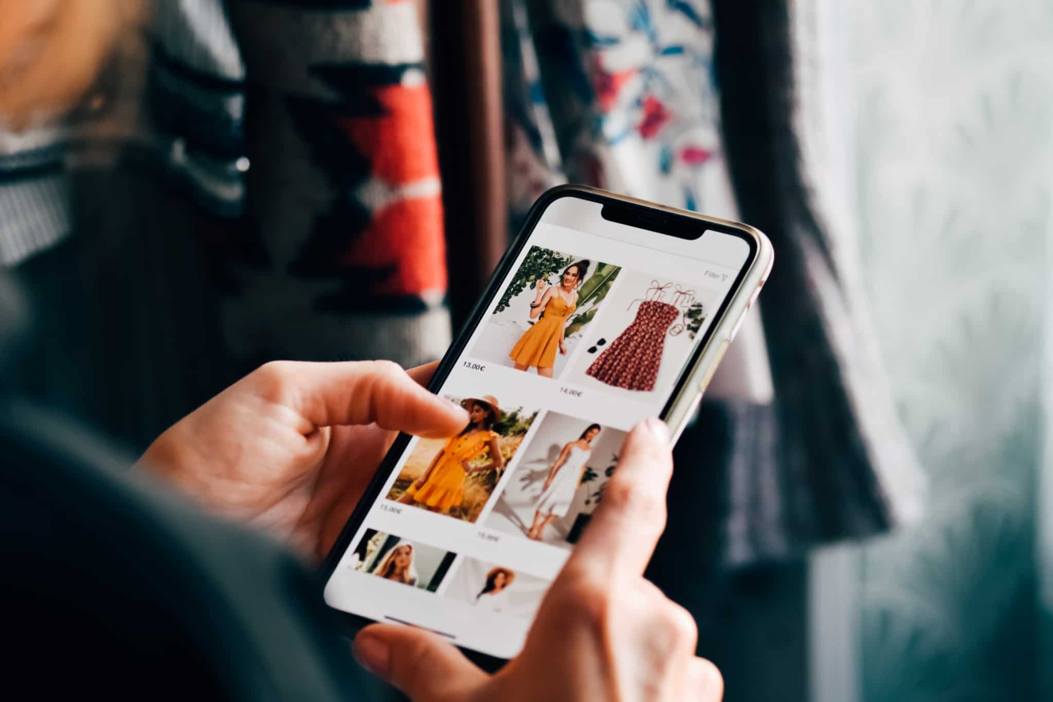pessoa a mexer no telemóvel a ver vestidos online