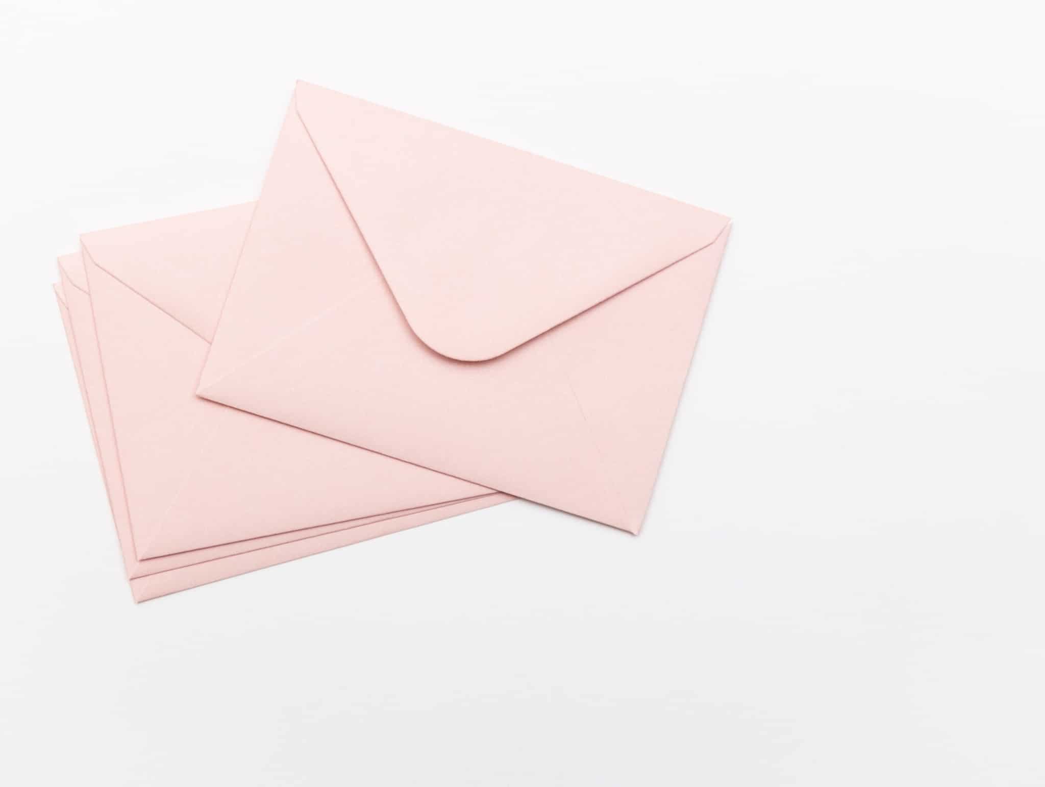 três envelopes cor de rosa