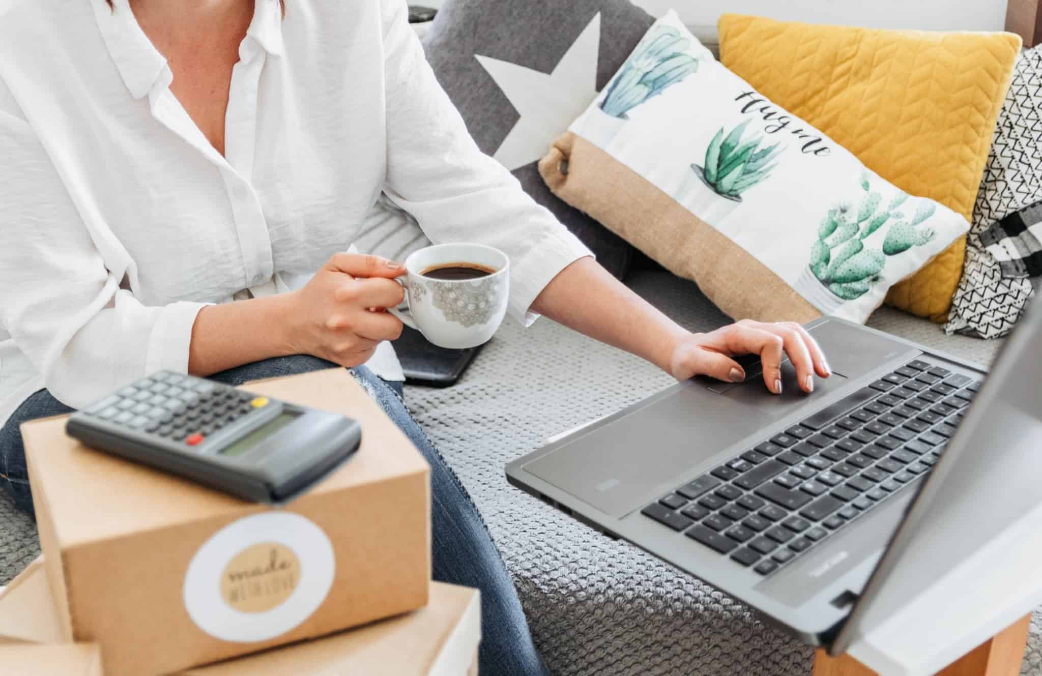 Criar uma loja online: usar uma plataforma ou contratar um web designer? mulher a mexer no computador e a beber uma chávena de café