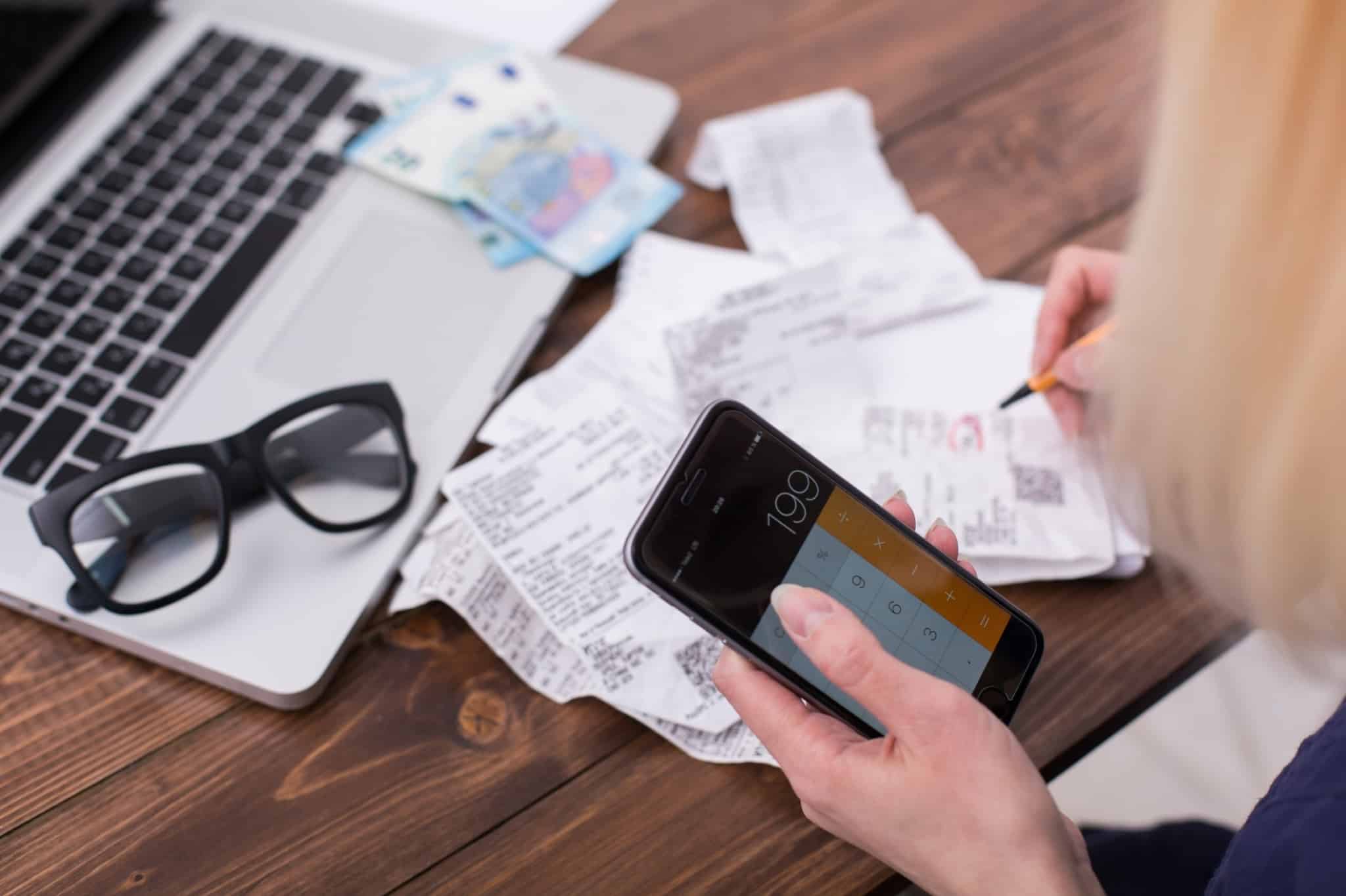 Mulher a fazer contas no telemóvel