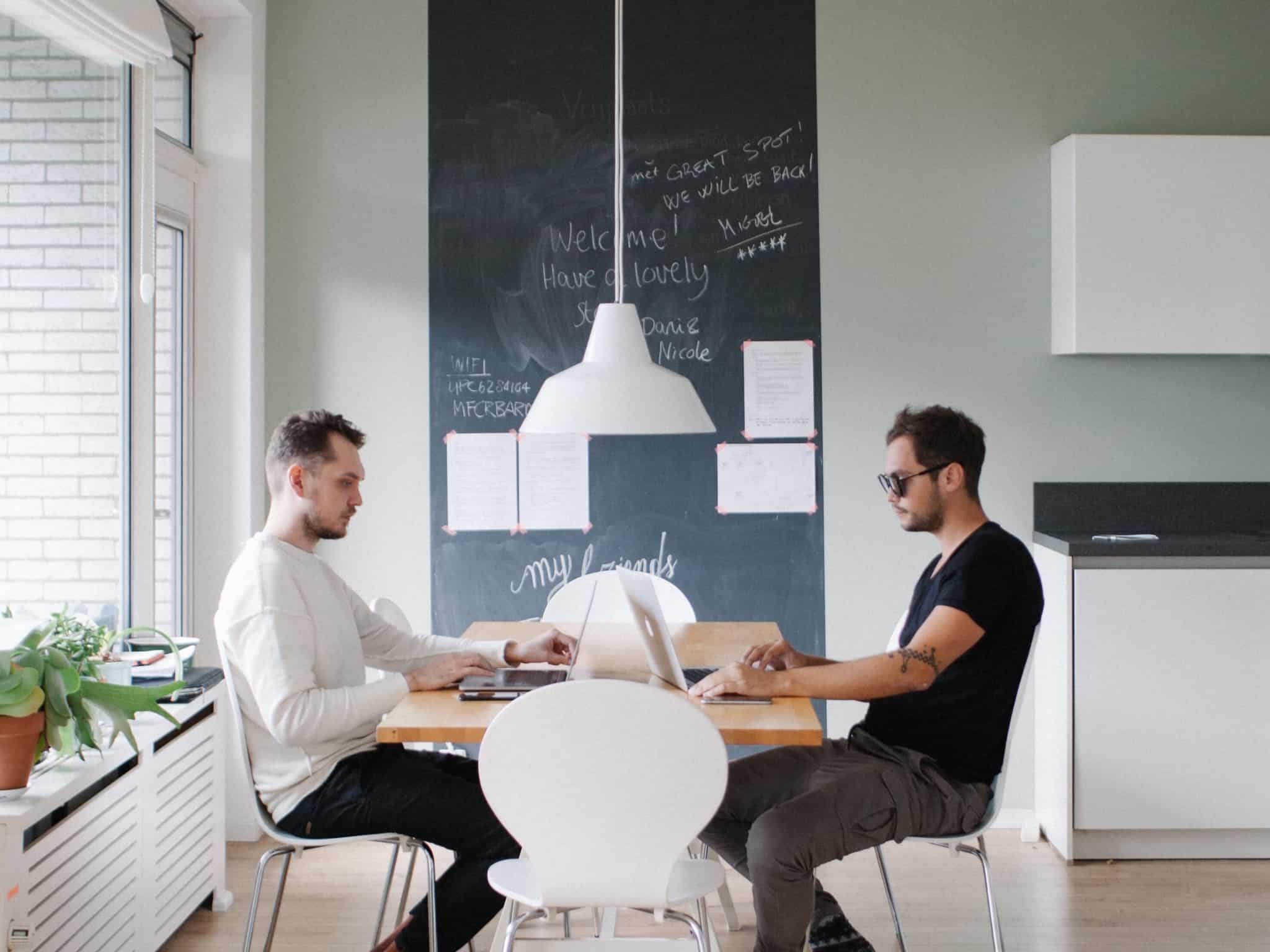 dois homens a trabalhar no escritório ao partilhar mesa