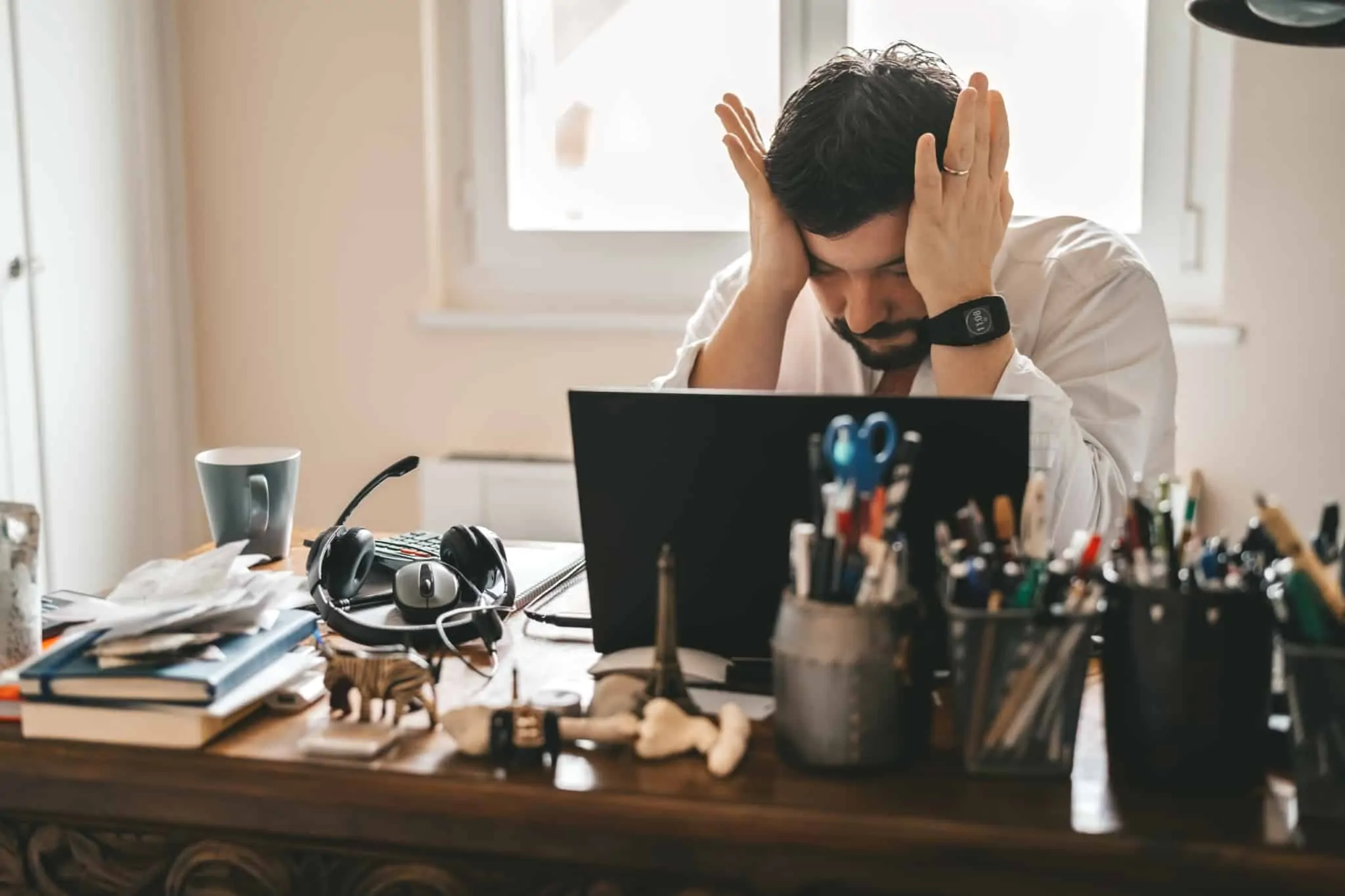 Em situação de desemprego, como posso proteger o meu crédito? Homem com ar preocupado em frente ao computador