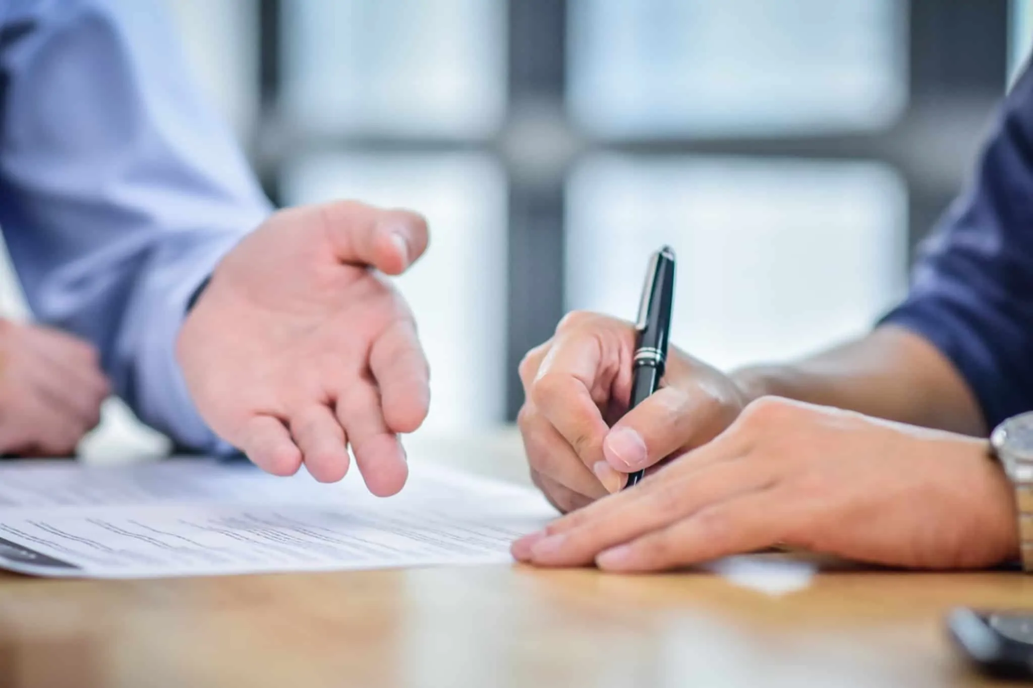 Rescisão por mútuo acordo: Quais são os direitos dos trabalhadores? uma pessoa a assinar um contrato