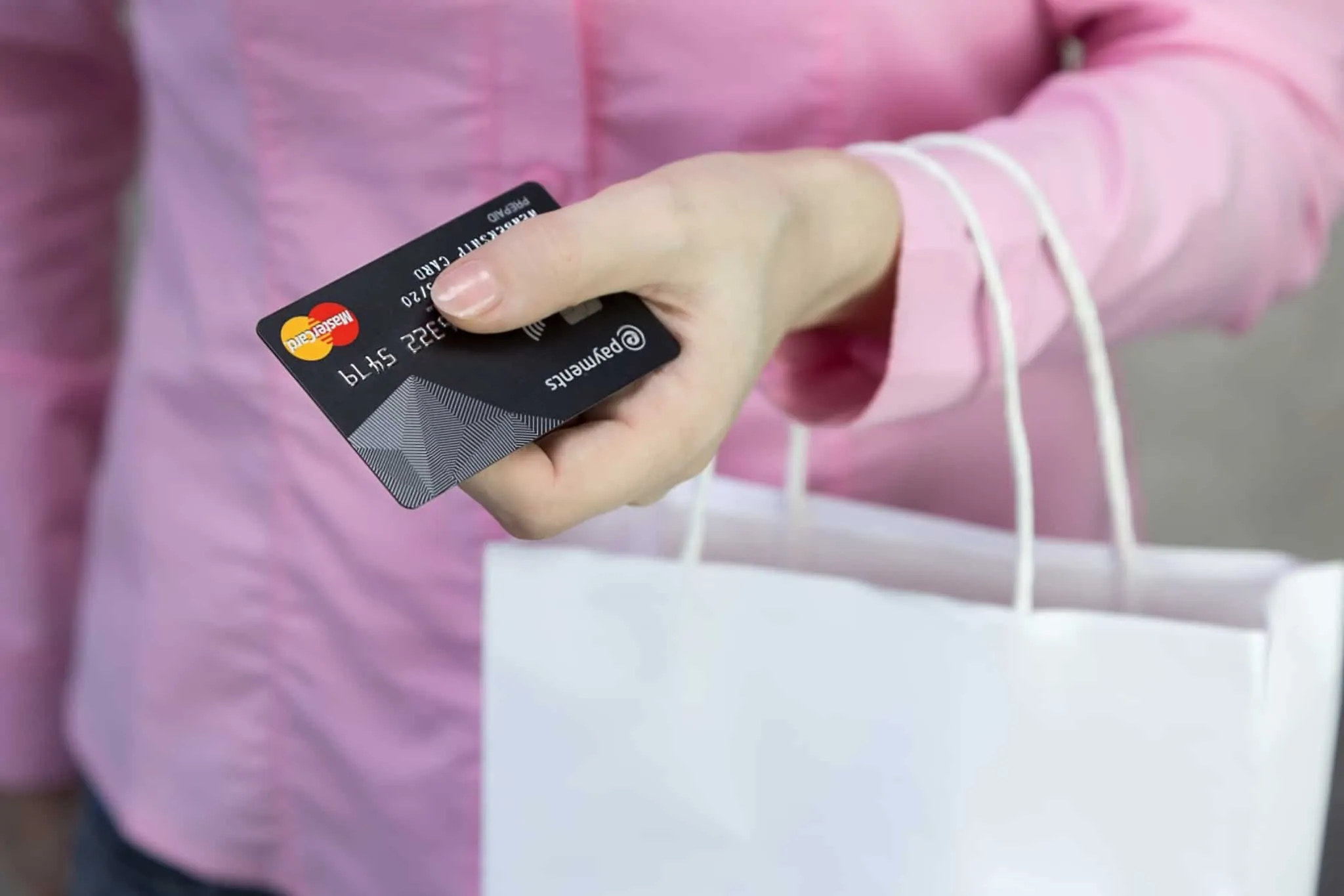 Cartões de crédito premium: Quais são os benefícios mais comuns? pessoa a segurar cartão de crédito preto