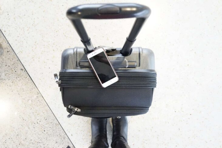 mala de viagem preta com um telemovel em cima