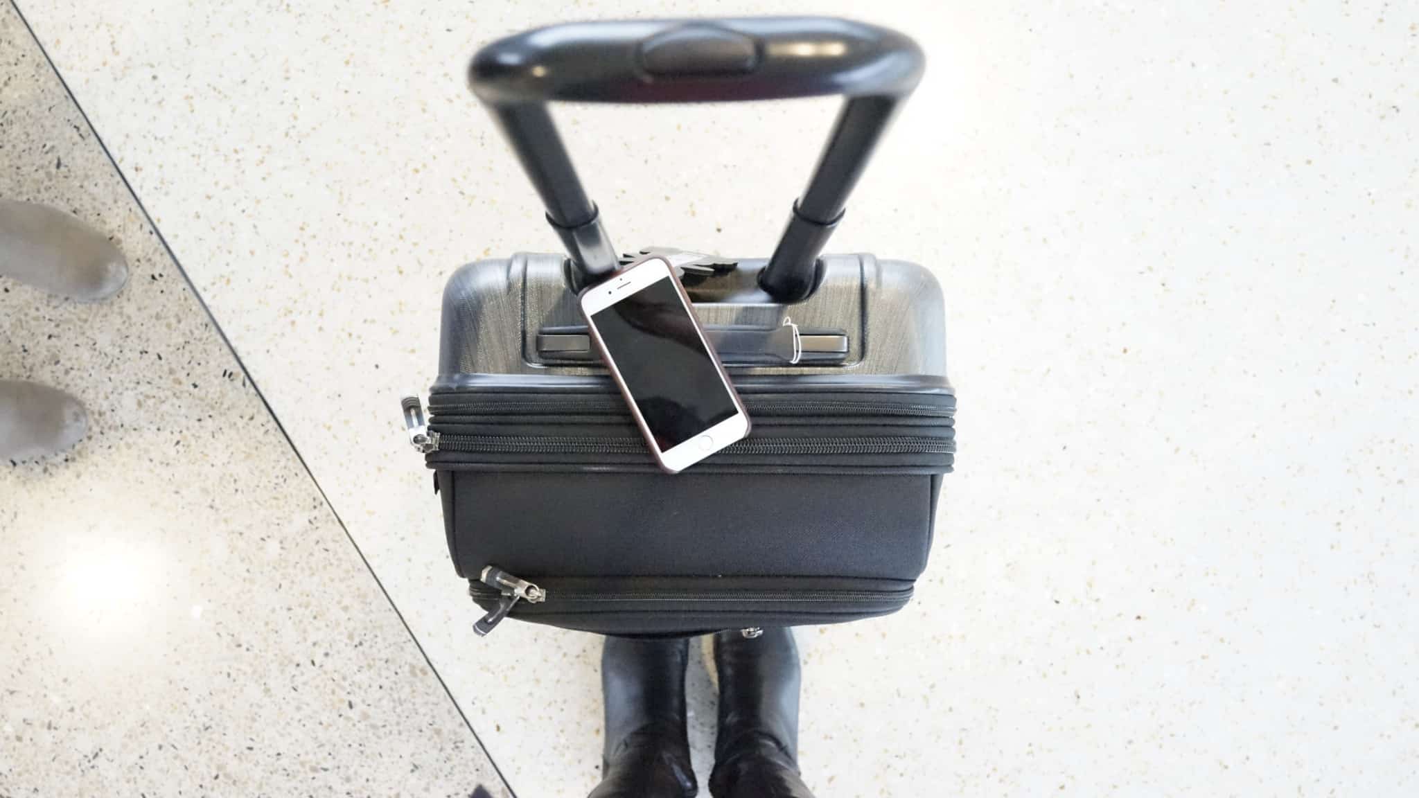 mala de viagem preta com um telemovel em cima