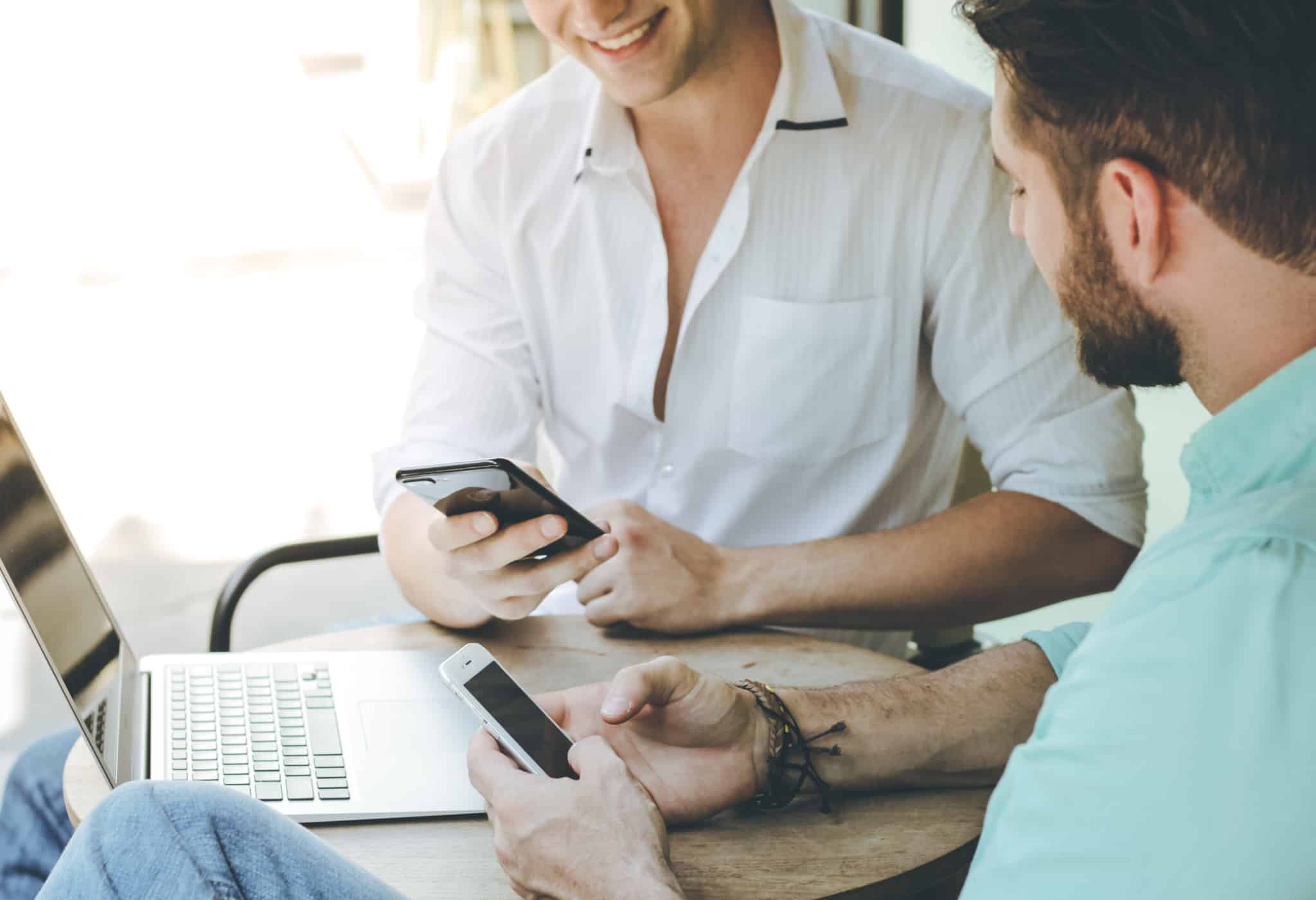 dois empresários a mandar mensagens pelo telemóvel