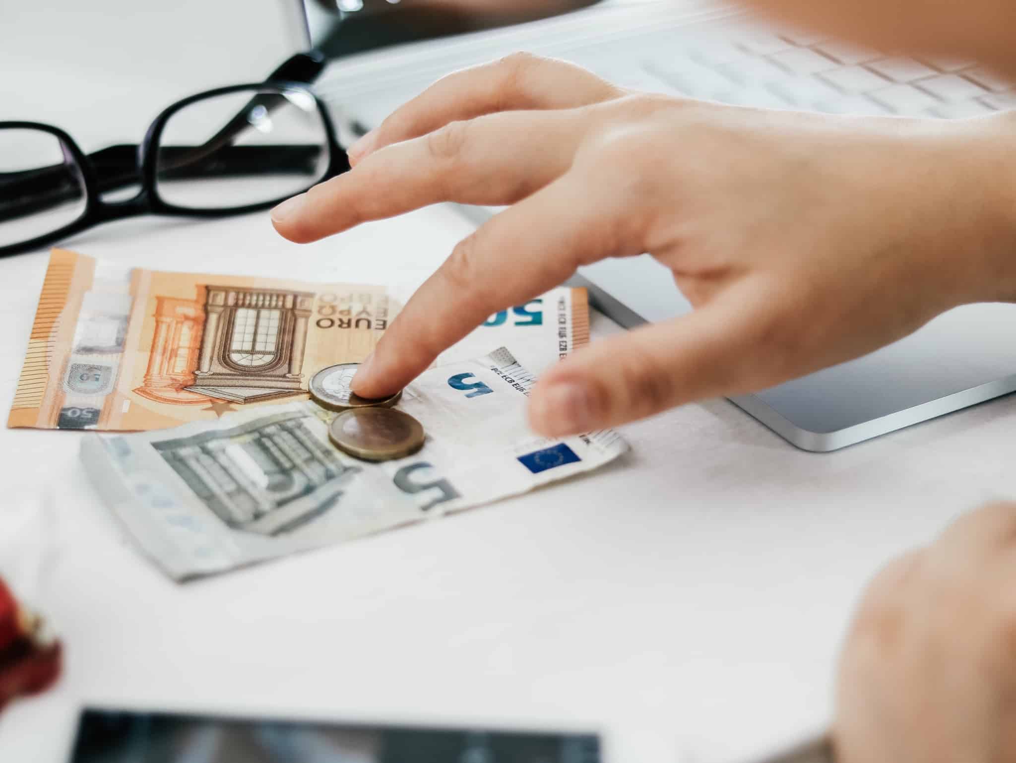pessoa a contar dinheiro - dinheiro em cima de uma mesa