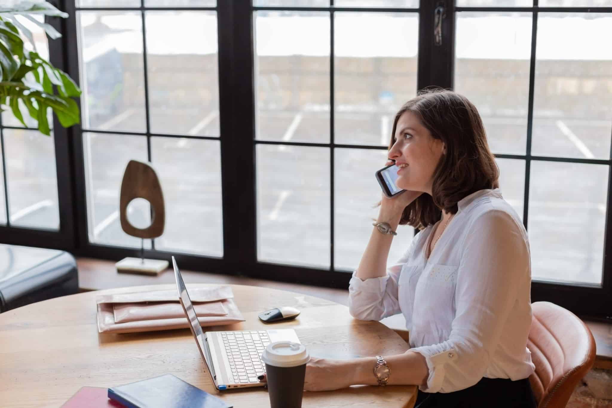 mulher a falar ao telefone e a trabalhar