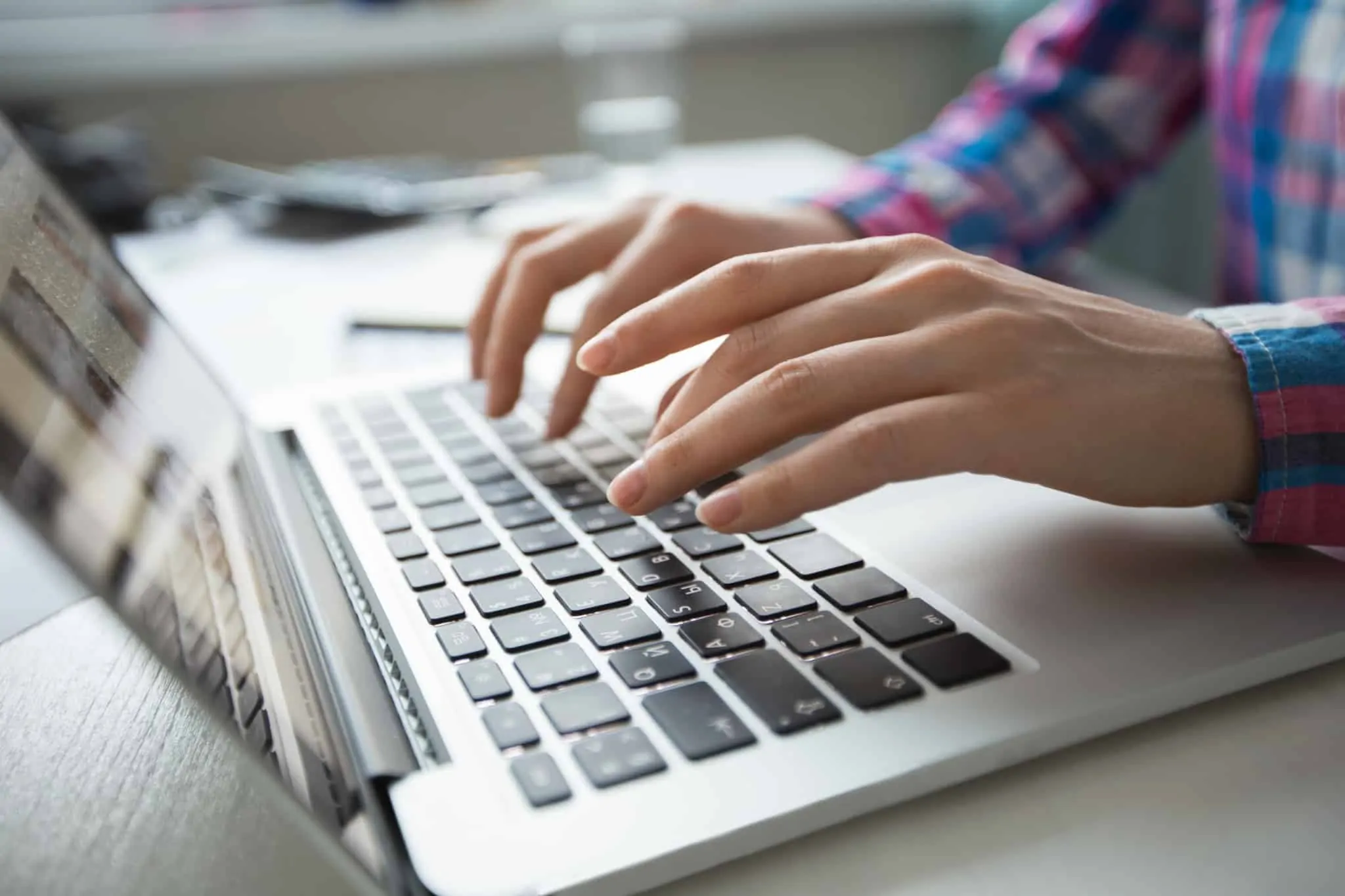 Como se despedir num email sem ser com “cumprimentos” Pessoa trabalha num portátil