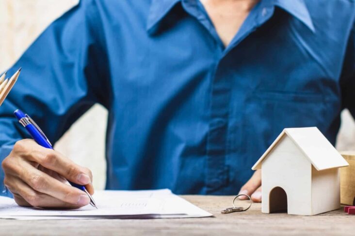 Homem assina um contrato de arrendamento de uma casa