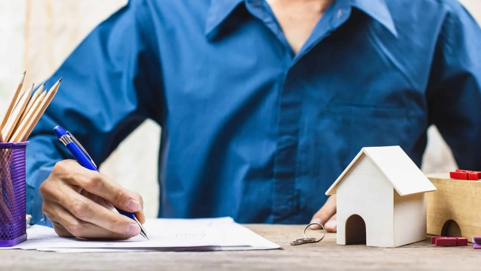 Como registar um contrato de arrendamento nas Finanças? Homem assina um contrato de arrendamento de uma casa