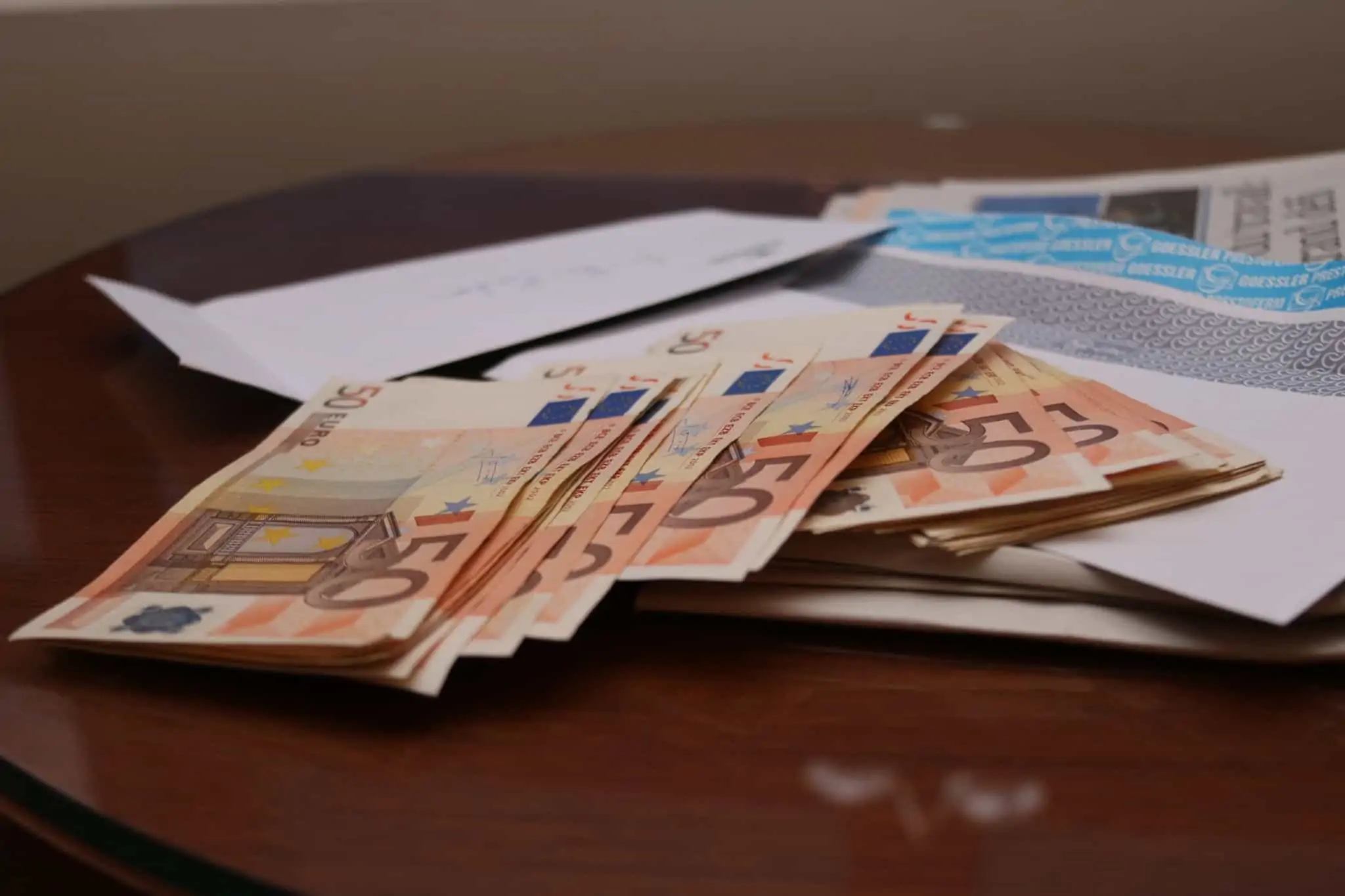 Doações: quando se tem de pagar impostos? Um maço de notas de 50 euros em cima de uma mesa de madeira