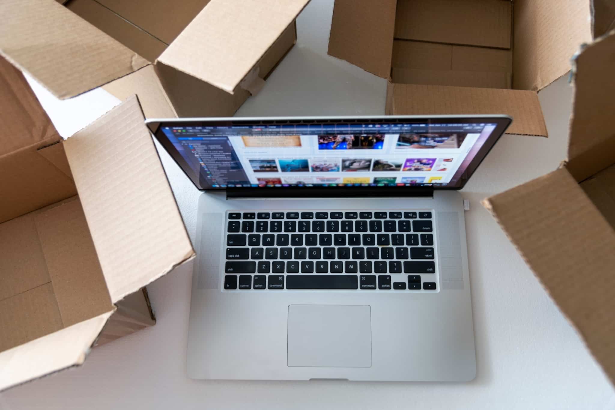 Dropshipping: Uma solução para avançar com o seu negócio? Um computador no chão rodeado de caixas
