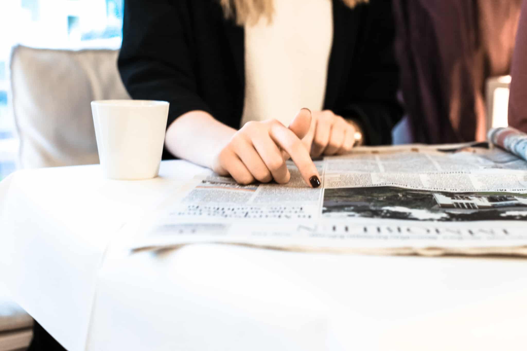 pessoa a ler o jornal para identificar fake news