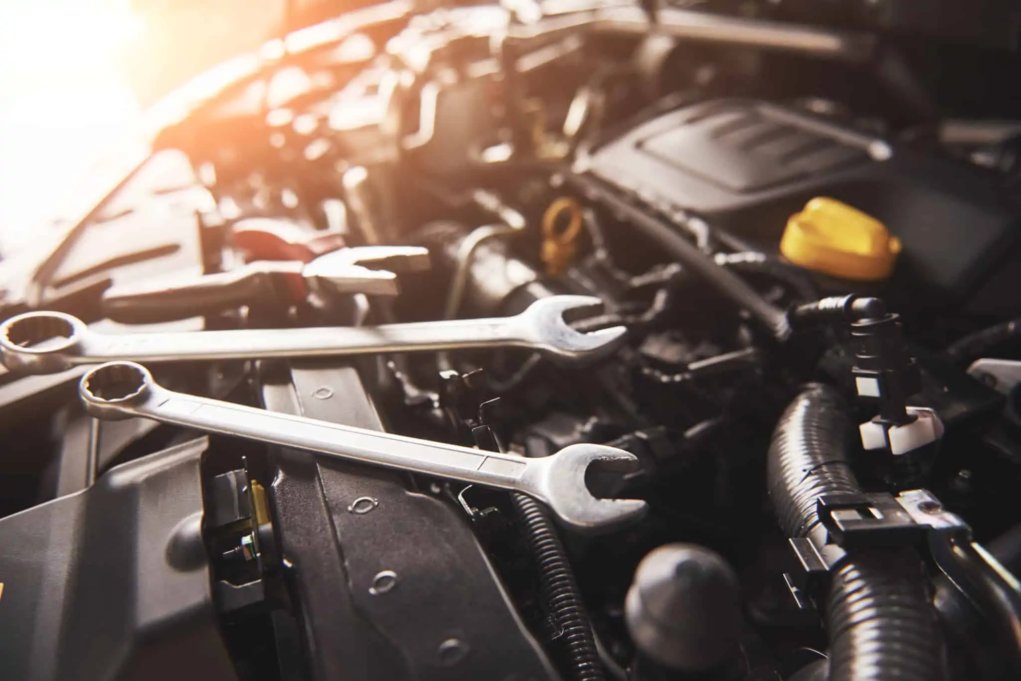 Dicas para comprar carro em segunda mão capot de um carro aberto com duas chaves de fendas em cima do motor