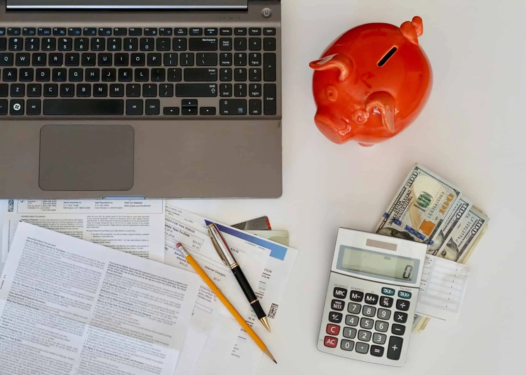 Débitos diretos: Como posso cancelar? uma mesa com notas, calculadora, faturas e computador