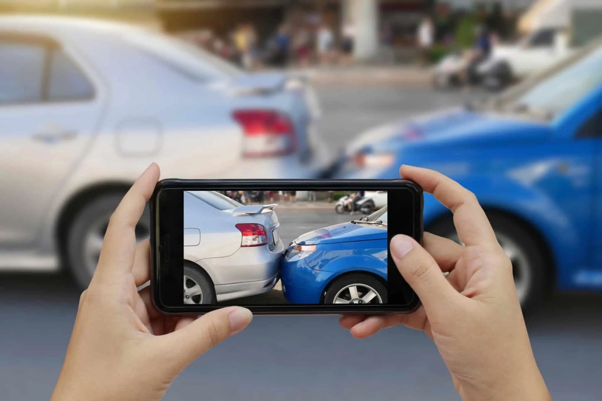 Cancelar o seguro automóvel: Saiba quando é possível e como fazê-lo Pessoa tira fotografia com o seu telemóvel a um acidente entre carros