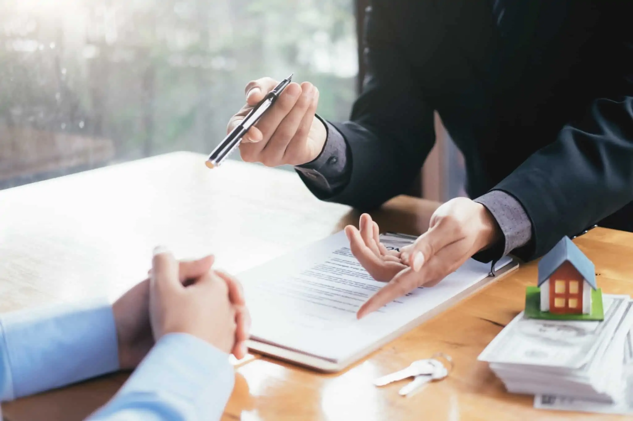 Em que situações posso ficar isento de pagar mais-valias imobiliárias? pessoas numa reunião de venda de um imóvel