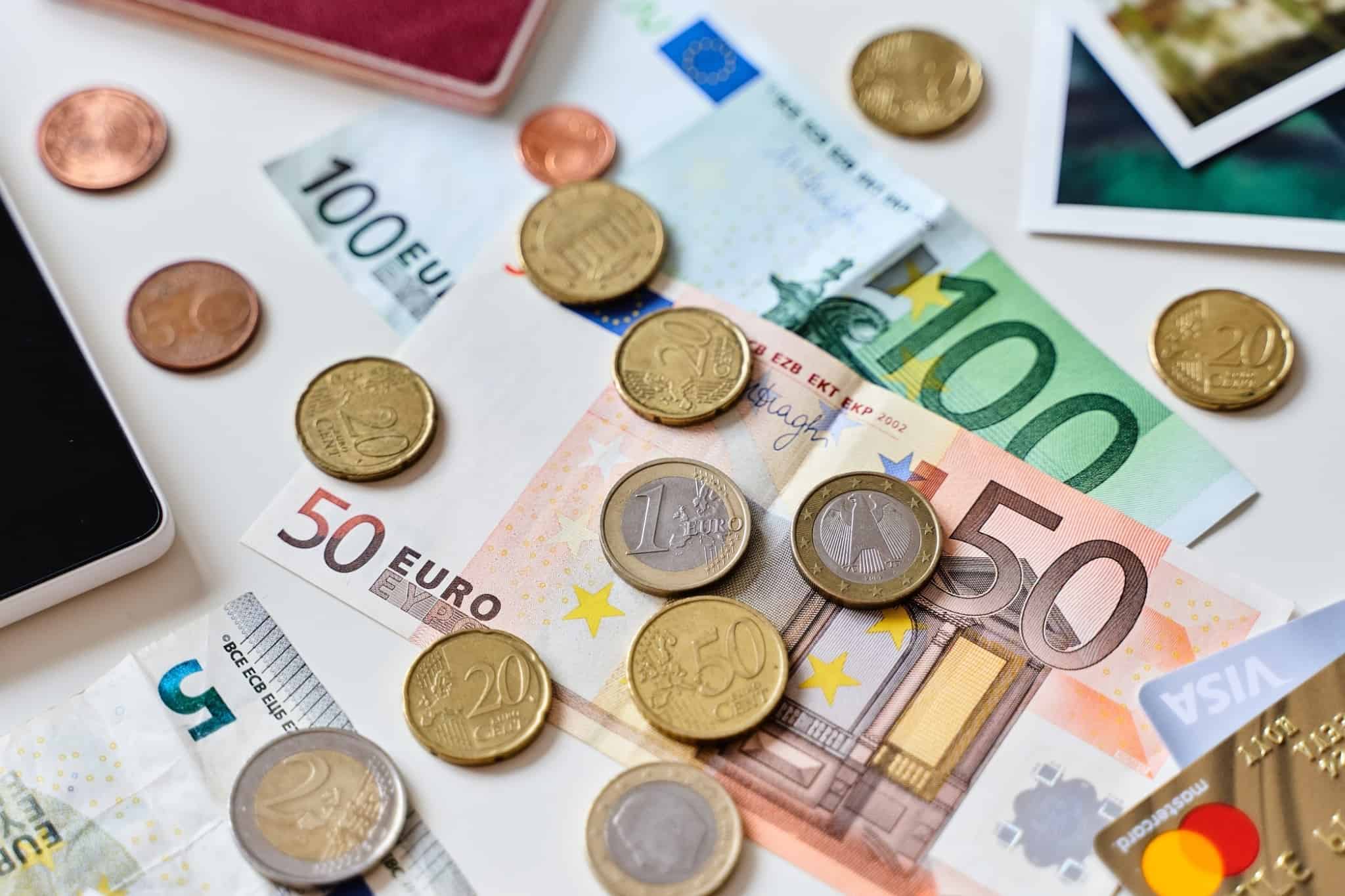 O (importante) papel dos Bancos Centrais nas nossas poupanças moedas e notas de euro espalhadas em cima de uma mesa