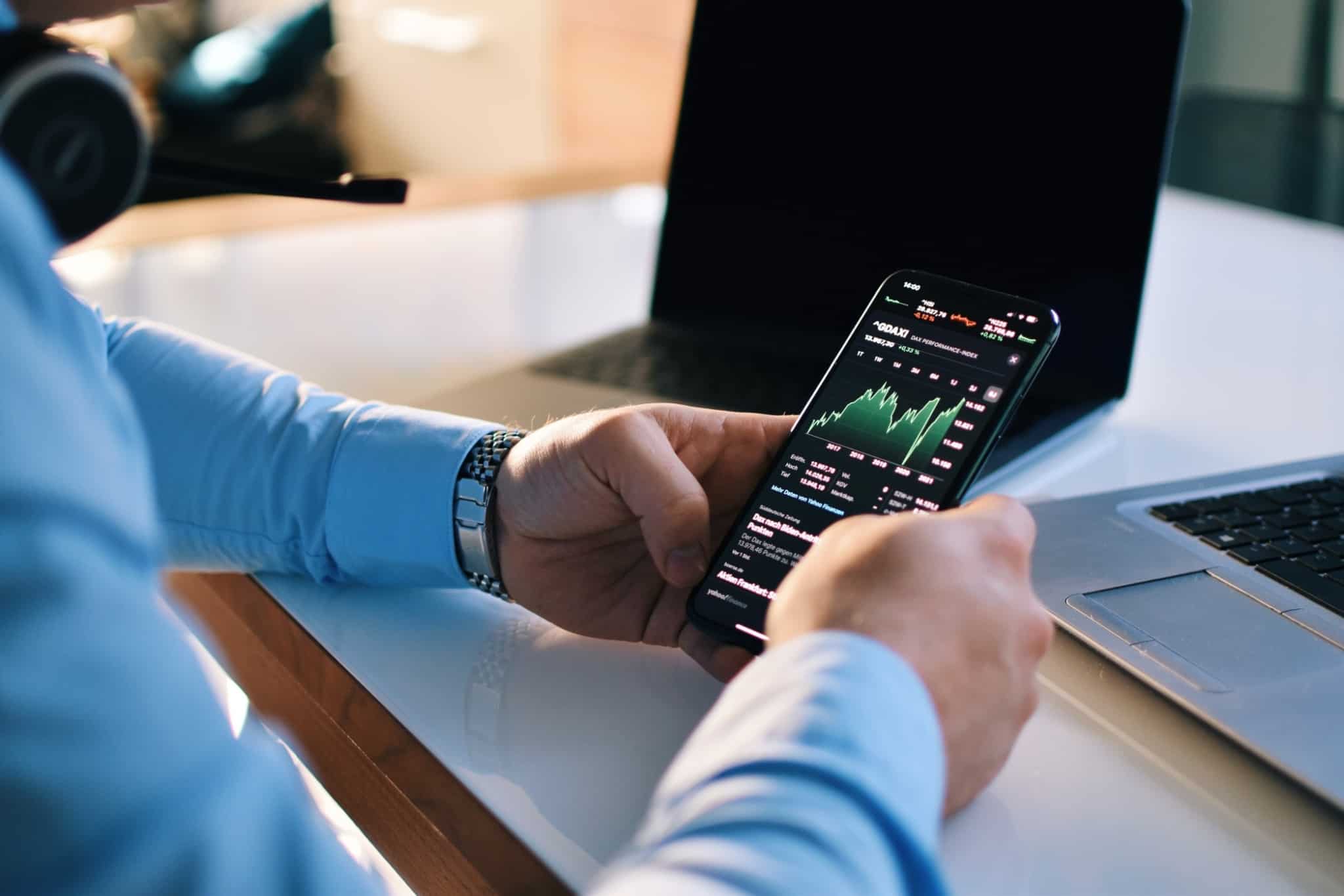 Investidor consulta a evolução dos seus investimentos através do seu telemóvel