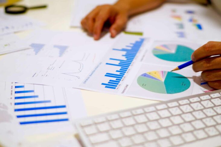 Mulher analisa vários gráficos co informação financeira de uma empresa