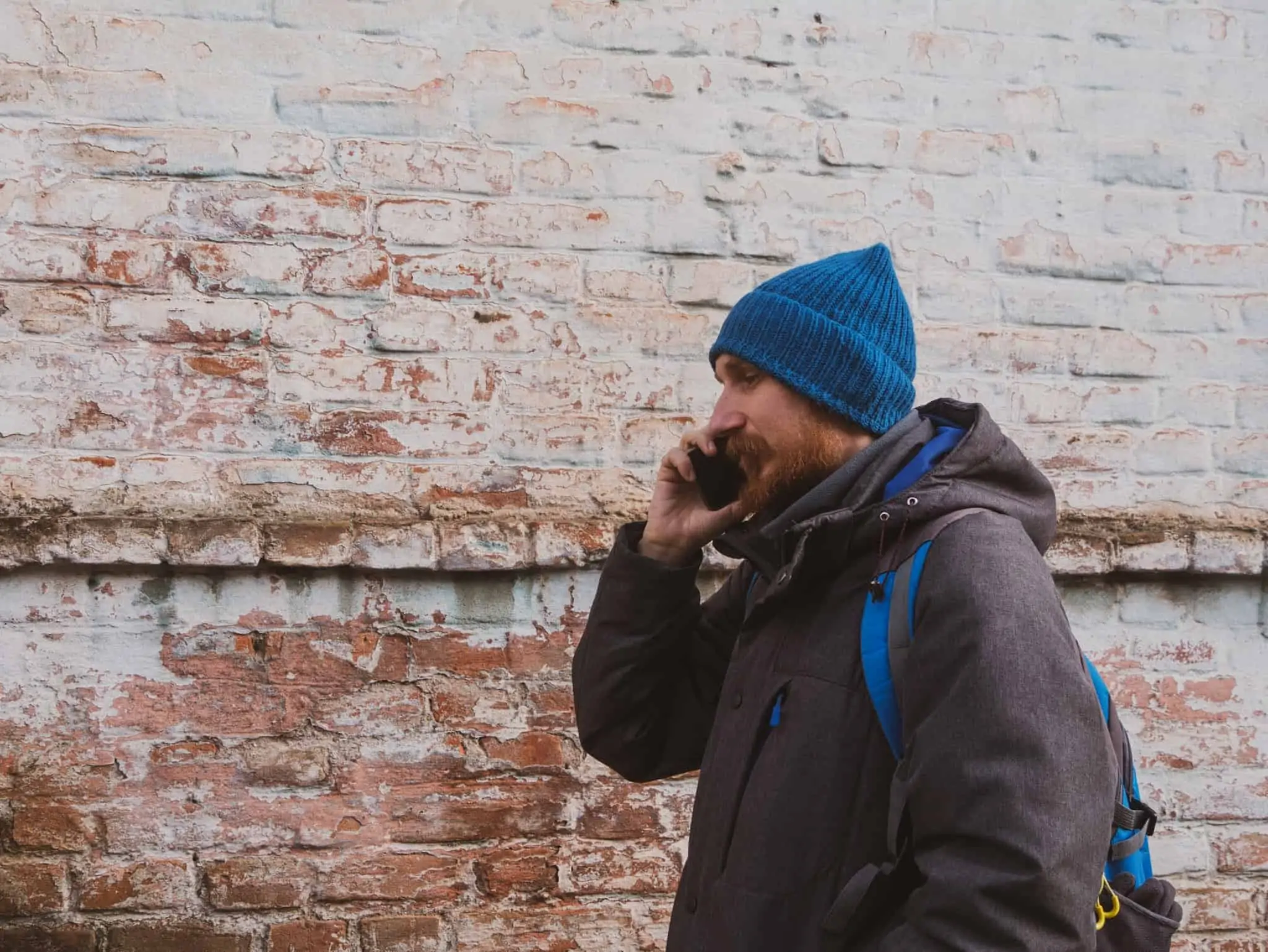 Homem de gorro fala ao telefone