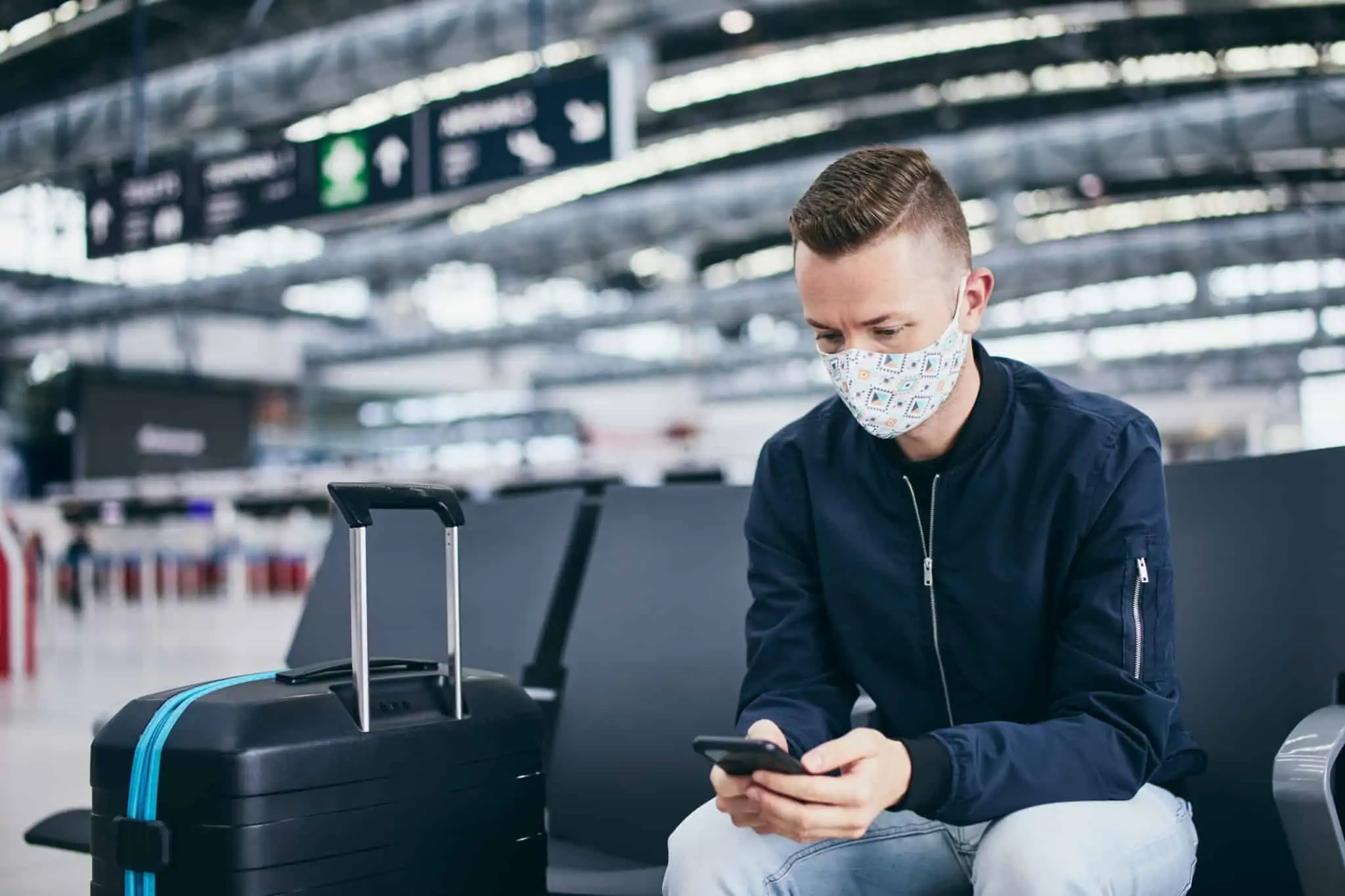 Certificado Digital COVID da UE: O que deve saber antes de viajar Homem sentado no aeroporto à espera do seu voo